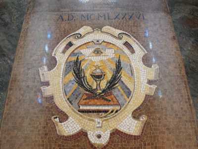 Ma la pi� grande sorpresa la ritroviamo sul pavimento, l� dove nei pressi dell�entrata un mosaico rappresenta  
la Bibbia, le palme, la colomba e il cosiddetto �occhio della provvidenza� posto all�interno di un triangolo. Quest�ultimo � un simbolo poco utilizzato dal Cristianesimo, perch� preso in prestito dalla Massoneria sin dal 700

